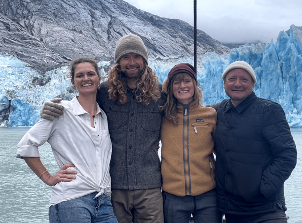 a group of people posing for a photo in front of a mountain