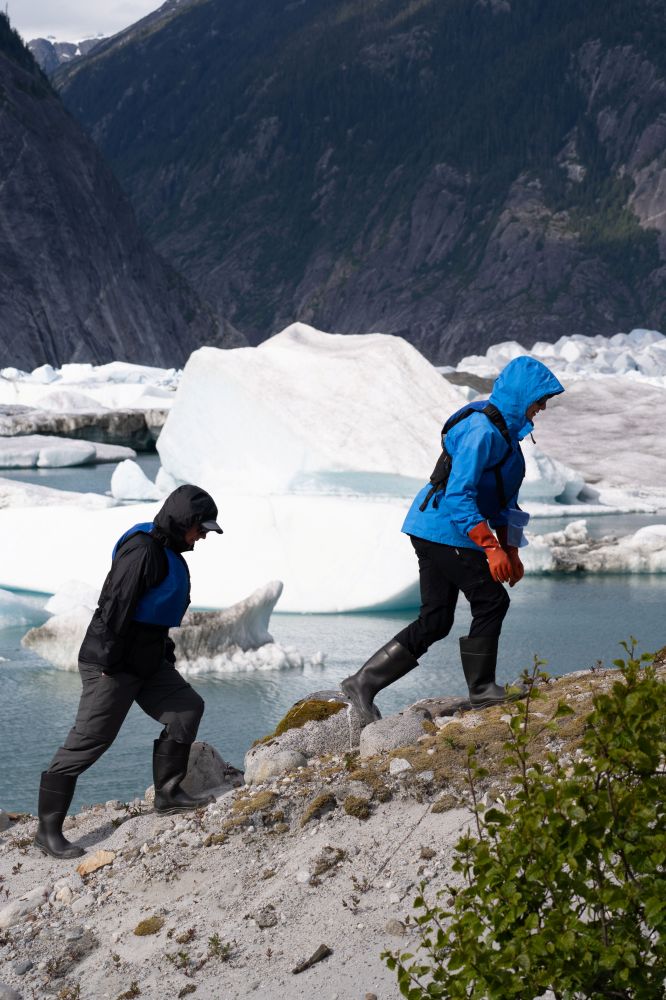 a couple of people that are walking on the side of a mountain